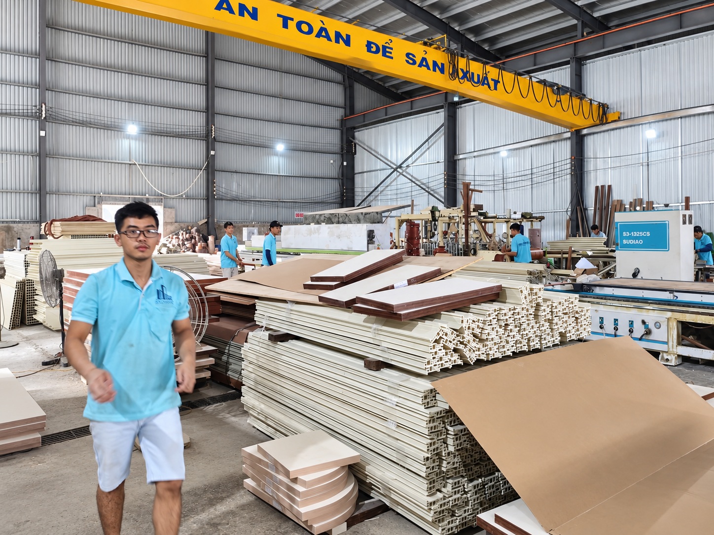 Khu vực sản xuất cửa nhựa Sumko Door với các thanh profile và tấm cửa xếp cạnh máy gia công