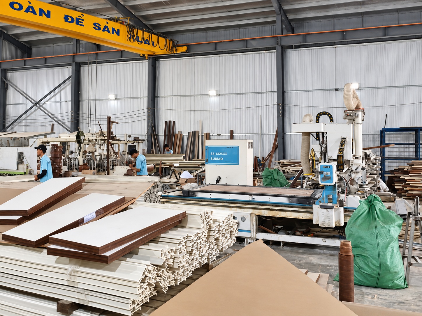 Máy gia công tại xưởng cửa nhựa Sumko Door cùng thanh profile và tấm cửa chờ xử lý