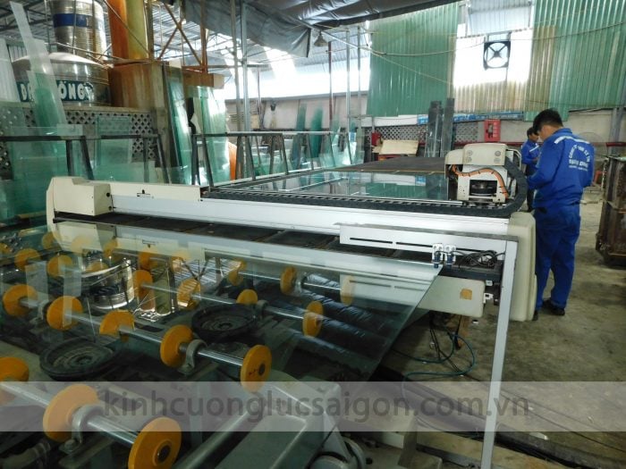 Người vận hành thiết bị gia công kính trong xưởng