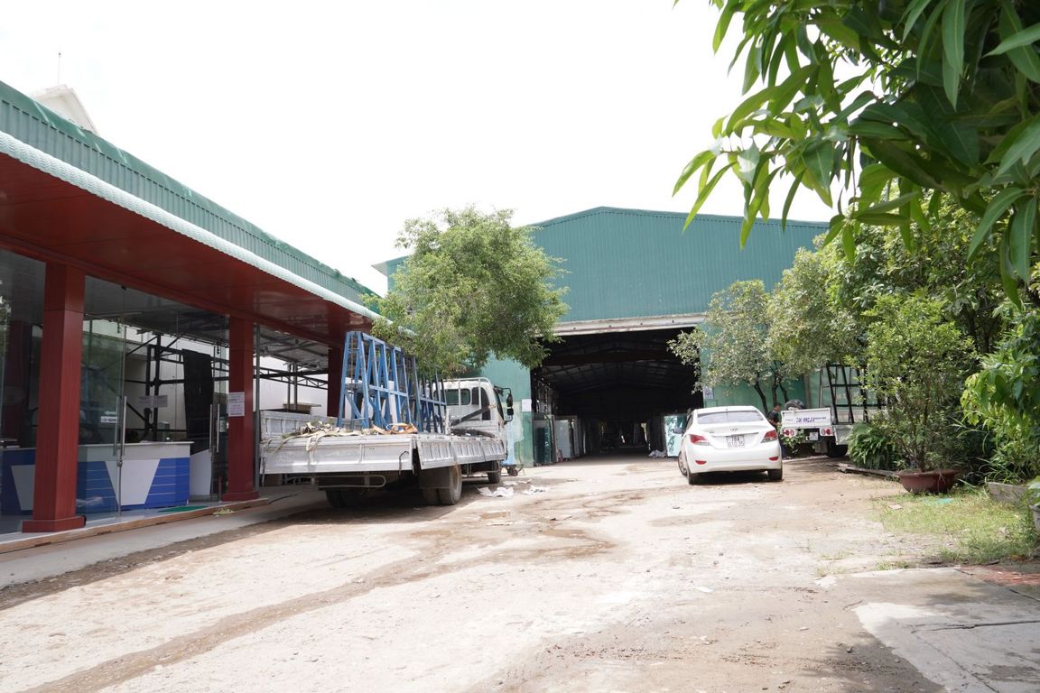 Lối vào nhà xưởng với xe tải và ô tô