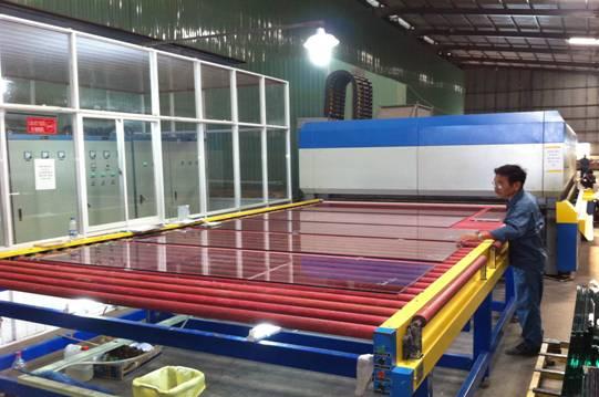 Người vận hành bên bàn con lăn trong xưởng kính