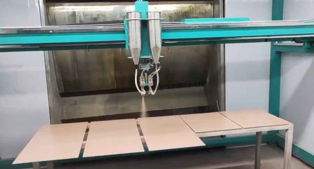 Máy phun sơn tự động trên kính đang vận hành trong buồng sơn có hệ thống thu bụi